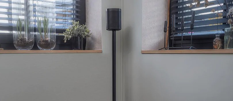 Multiroom speakers with speaker stands complete your listening experience. Multiroom speaker on speaker stand in living room.