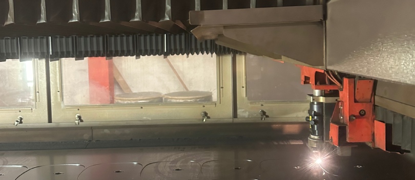 Voeten van speaker standaarden gesneden uit metalen platen. Een zijaanzicht van een snijmachine die voeten uit metalen platen snijdt