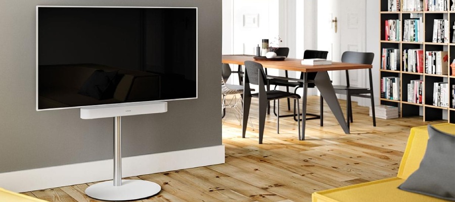 White Television on a white stand with a white soundbar in the living room.